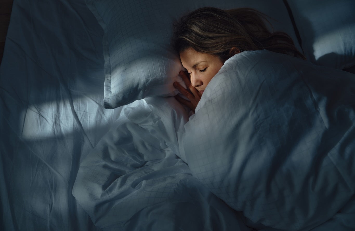 A woman sleeping soundly in bed at night
